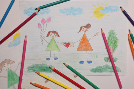 Beautiful child's drawings and pencils on white background, flat layの写真素材