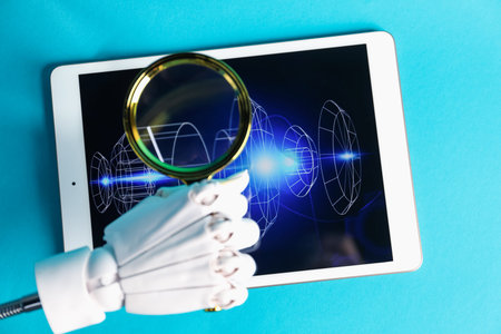 Hand holding magnifying glass above tablet with 3d model of modern equipment on light blue...