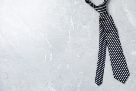 Stylish striped tie on light gray table, top view. Space for textの写真素材