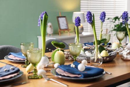 Easter celebration. Festive table setting with flowers and painted eggs indoors