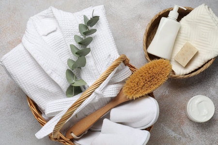 Flat lay composition with bathrobe and spa essentials on light gray background