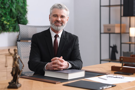 Portrait of smiling notary in suit with book at table in office