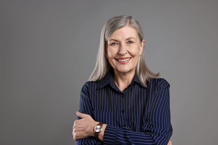 Portrait of beautiful senior woman on gray backgroundの写真素材