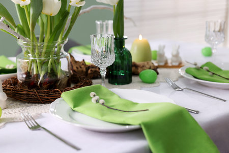 Easter celebration. Festive table setting with elegant dishware and willow branches, closeup