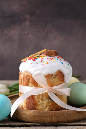 Delicious Easter cake and painted eggs on wooden table, closeup