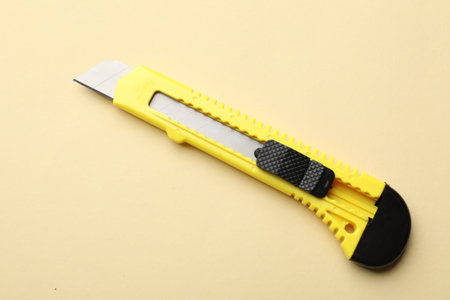 One sharp knife on beige background, top view