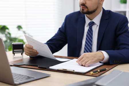 Notary working at wooden desk in office, closeup