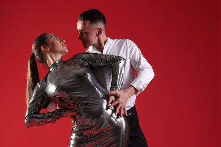 Couple of professional dancers on red background