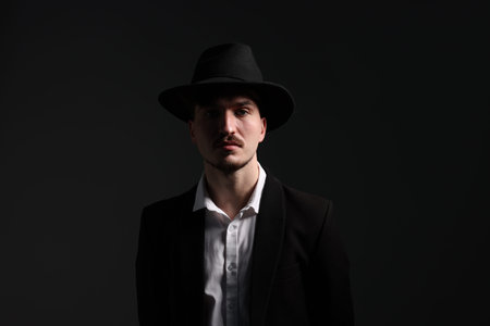 Man in stylish hat on dark background