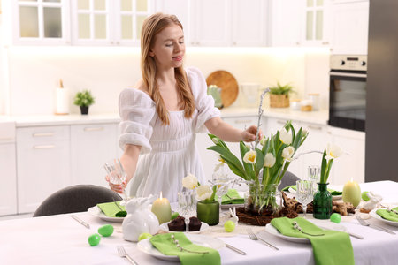 Woman arranging beautiful flowers at home. Easter table setting