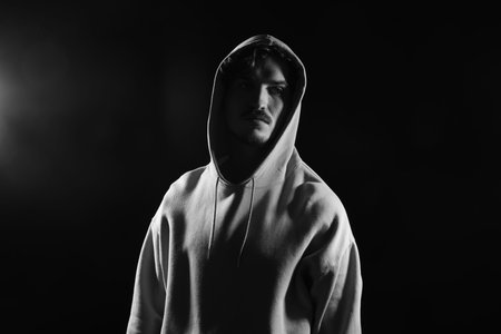 Man in hood on dark background. Black and white effectの写真素材