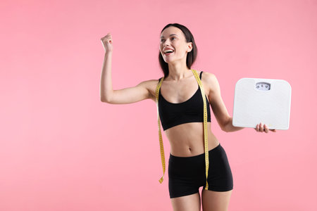 Woman with scales and measuring tape on pink background, space for text