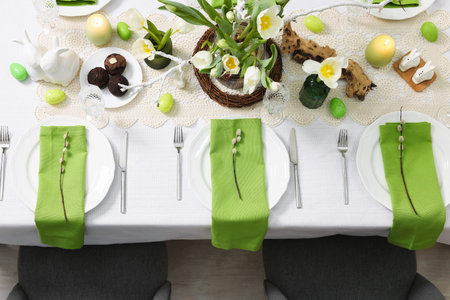 Festive table setting with elegant dishware and flowers, top view