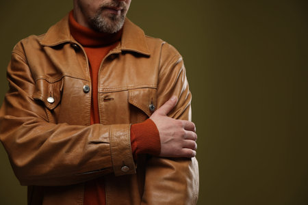 Man in leather jacket on color background, closeup. Space for textの写真素材