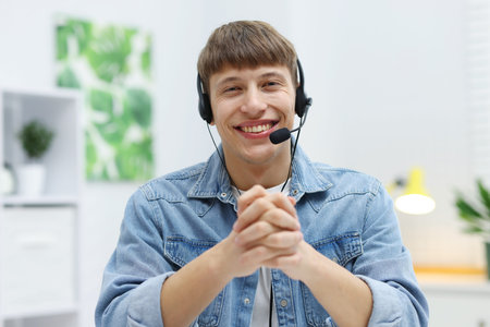 Portrait of smiling hotline operator in headset in office