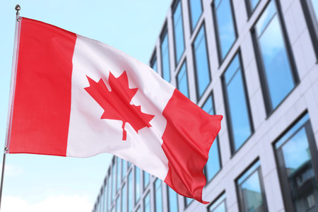 Flag of Canada waving near building outdoors.の写真素材