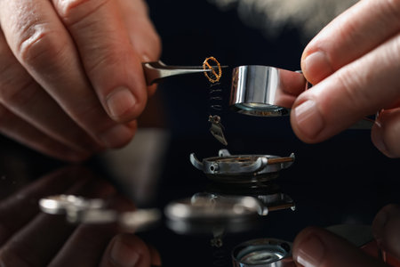 Senior man fixing mechanism of vintage wrist watch at mirror table, closeupの写真素材