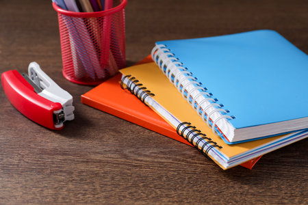Homework. Notebooks and different stationery on wooden table, closeup