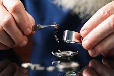 Senior man fixing mechanism of vintage wrist watch at mirror table, closeupの写真素材