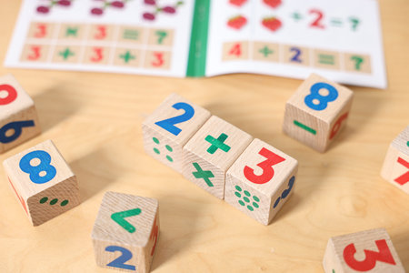 Wooden cubes with mathematical formula on table, closeup
