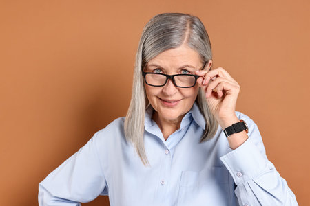 Portrait of beautiful senior woman on brown background