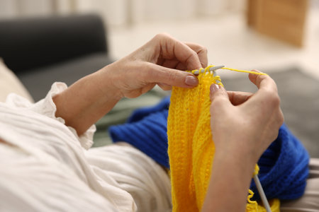 Senior woman knitting with needles at home, closeupの写真素材