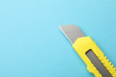 One utility knife on light blue background, top view. Space for textの写真素材