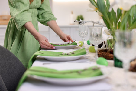 Woman setting festive table for Easter celebration at home, closeupの写真素材