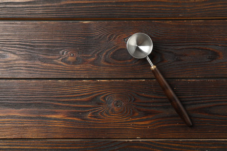 Metal scoop for ice cream on wooden table, top view. Space for text