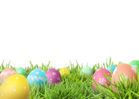 Easter eggs in green grass against white background