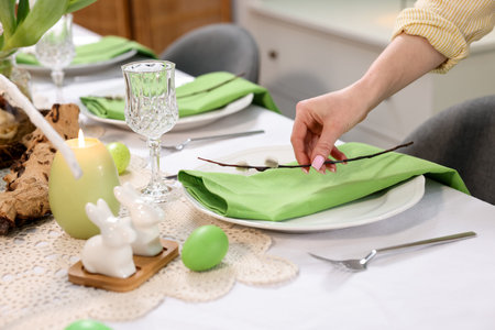 Woman setting festive table for Easter celebration at home, closeupの写真素材