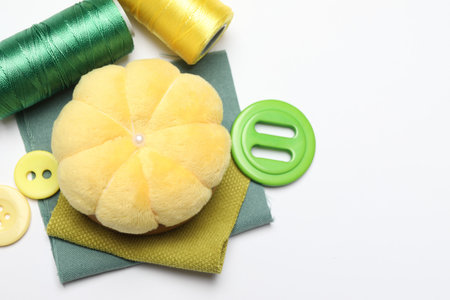 Flat lay composition with different sewing supplies on white background, space for text
