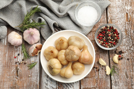 Pickled garlic, fresh vegetables and aromatic spices on color wooden table, flat layの写真素材