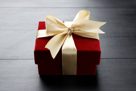 Beautiful velvet gift box on black wooden table, closeup