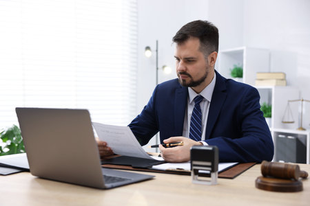 Notary working at wooden desk in office