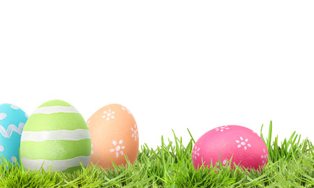 Easter eggs in green grass against white background