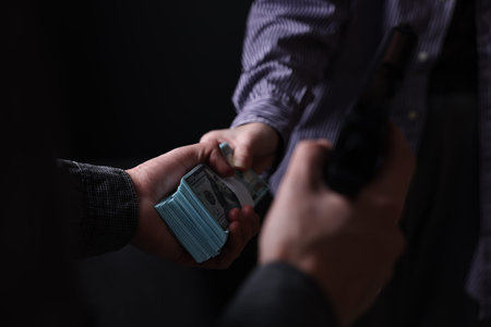 Hands exchanging money in a dimly lit room, closeup.