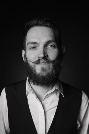 Man with stylish mustache on dark background. Black and white effect