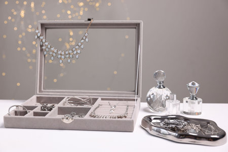 Different stylish jewelery in box on white table, closeup
