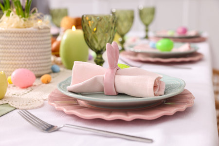 Easter celebration. Festive table setting with floral decor and painted eggs indoors, closeup