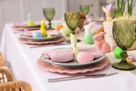 Easter celebration. Festive table setting with floral decor and painted eggs indoors, closeup