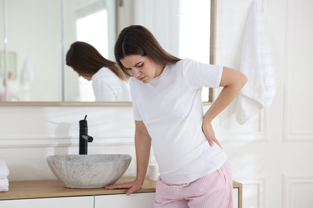 Pregnant woman suffering from pain in bathroom