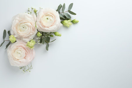 Beautiful ranunculuses and roses on white background, flat lay. Space for text
