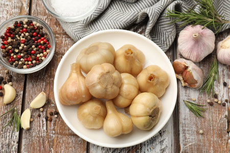 Pickled garlic, fresh vegetables and aromatic spices on color wooden table, flat layの写真素材