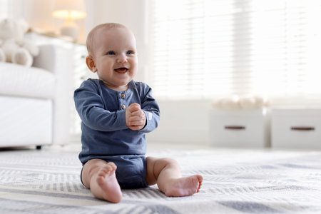 Cute little baby on floor at home, space for text