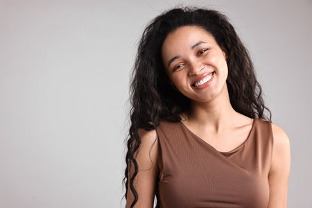Portrait of beautiful young woman on light gray background, space for textの写真素材