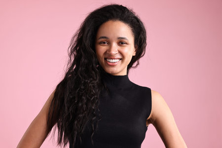 Portrait of beautiful young woman on pink background