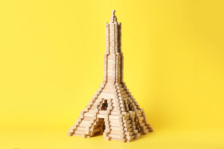 Eiffel tower made of wooden blocks on yellow backgroundの写真素材