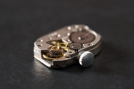 Mechanism of vintage wrist watch on black table, closeup