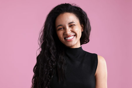 Portrait of beautiful young woman on pink backgroundの写真素材